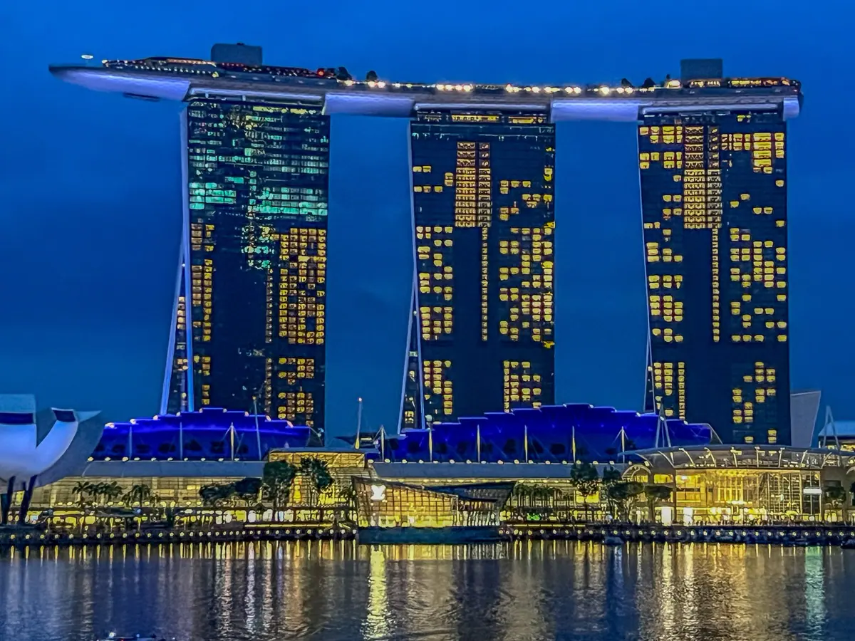 Marina Bay Sands in Singapore lit at night with reflections on the water